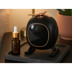 Czarny głośnik Bluetooth z wyświetlaczem i aromaterapią na stoliku