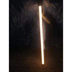 Świecąca tuba LED o długości 120 cm z kablem i wtyczką na tle ciemnego materiału