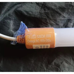 Świetlówka tuba LED o pomarańczowej barwie światła na czarnym tle