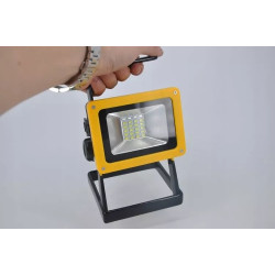 Akumulatorowy halogen LED 10W z uchwytem i żółtą podstawą, widoczne diody SMD i reflektor