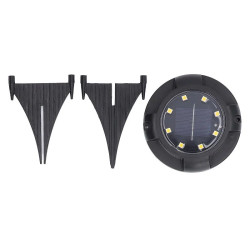 Zestaw 4 czarnych lamp solarnych wbijanych do ziemi z widocznym panelem i diodami LED