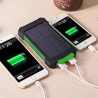 Power bank solarny czarno-pomarańczowy z panelem słonecznym i białym kablem USB