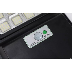Czarna latarnia solarna LED z panelem solarnym i czujnikiem ruchu zamontowana na białym uchwycie rurowym