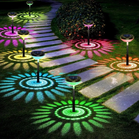 Dwie czarne lampy solarne ogrodowe wbijane w ziemię tworzące kolorowe okrągłe wzory świetlne RGB