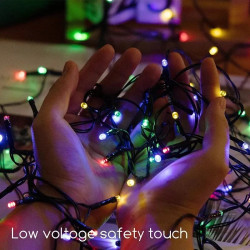 Kolorowy łańcuch lampek solarnych z panelem słonecznym na zewnątrz na drzewie